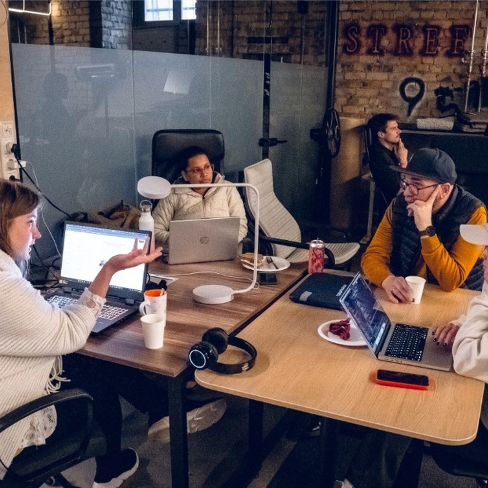Small team huddled around laptops at Double9